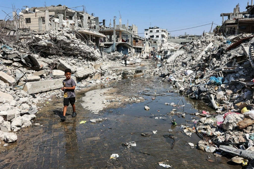 Child walking through flooded rubble