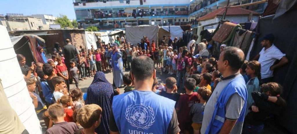 UNRWA workers distributing aid to children in a refugee camp